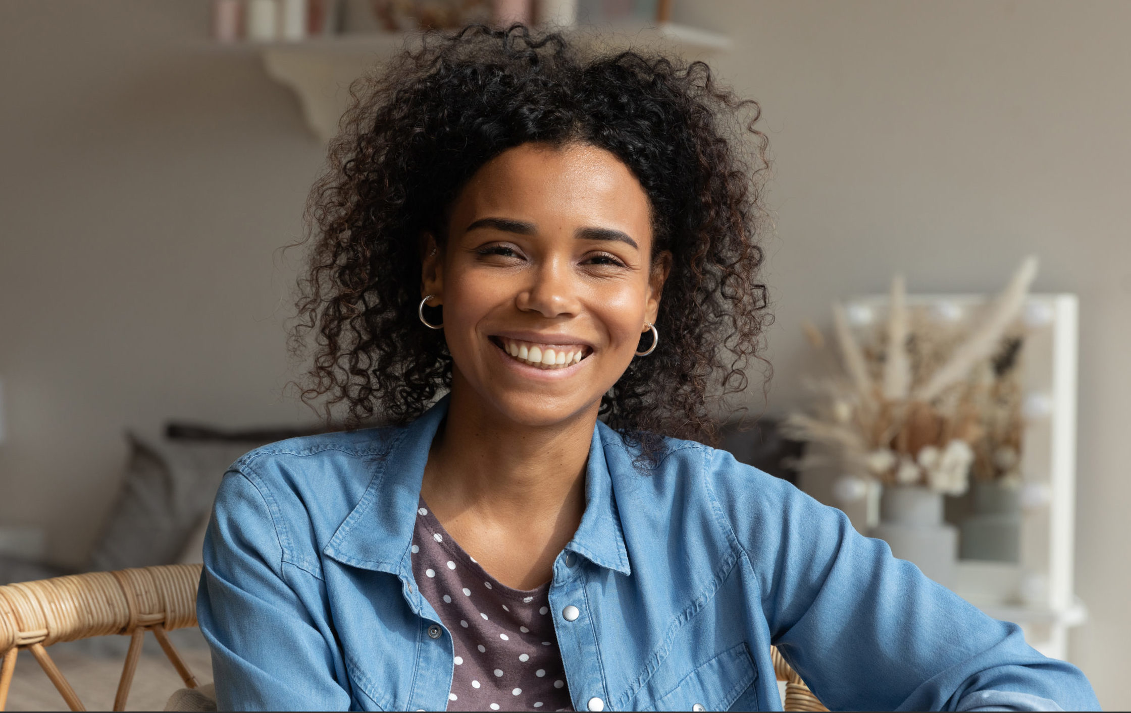 A smiling young black woman in a blue shirt