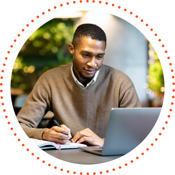 man with laptop taking notes