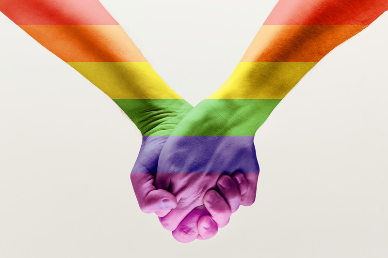 a rainbow Pride overlay over two people holding hands
