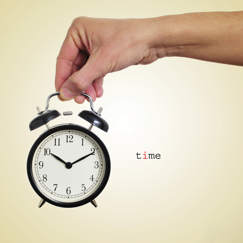 hand holding alarm click with the word time