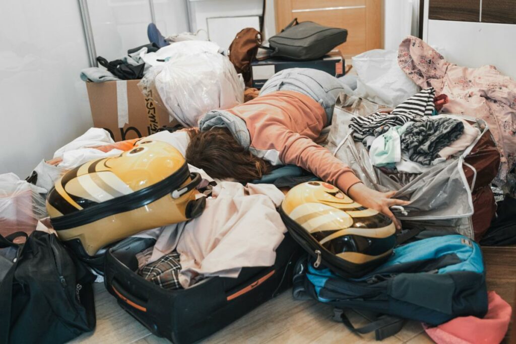 a woman laying down on top of several opened suitcases